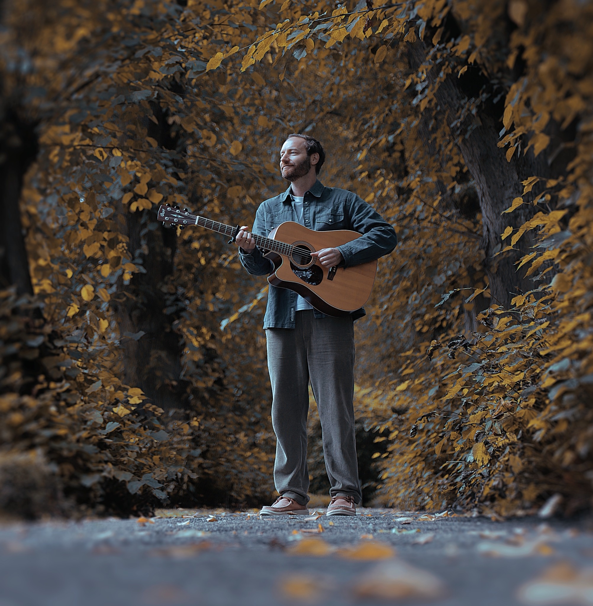 Sven Ferdinand mit Gitarre im Wald
